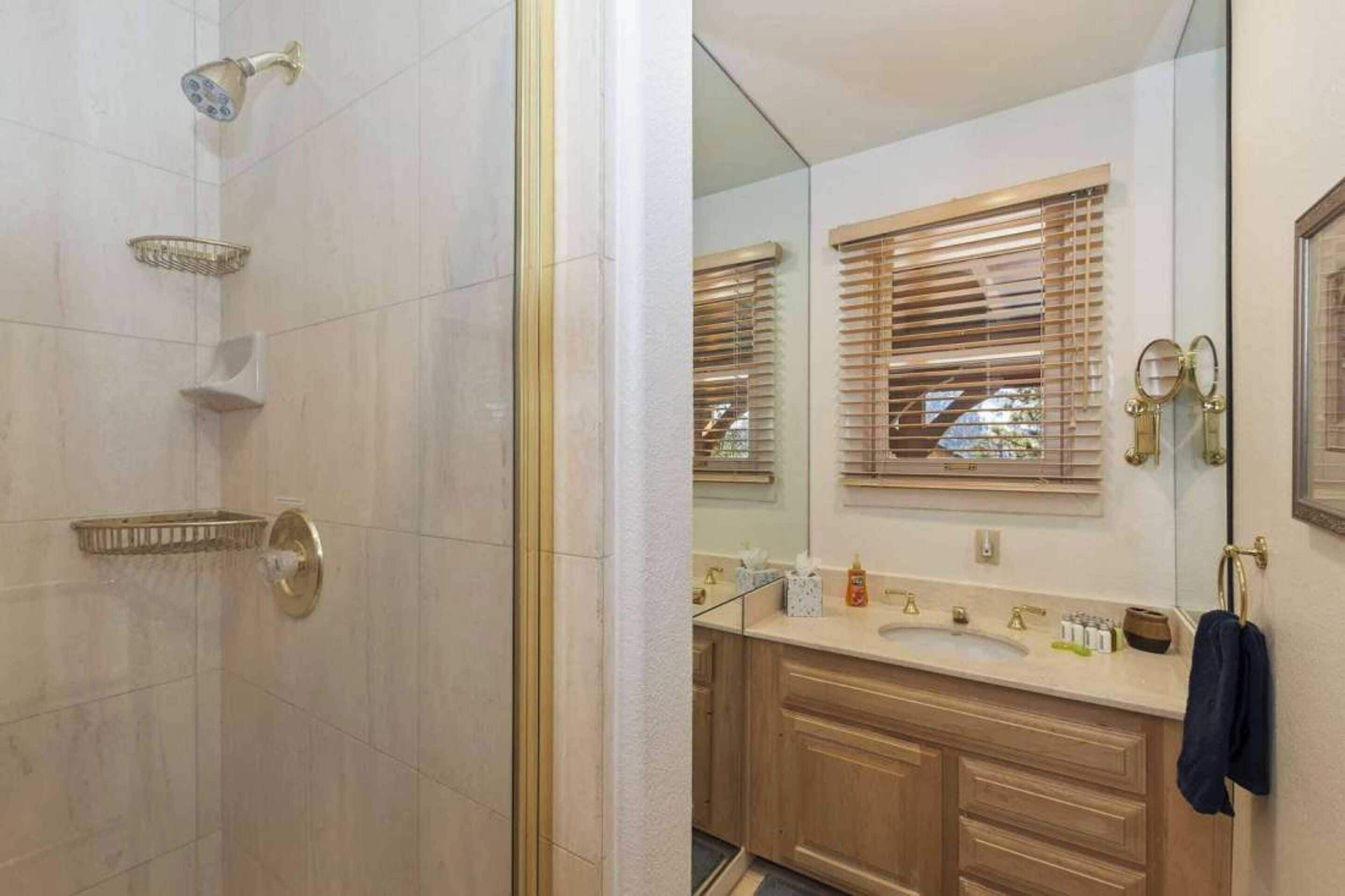 A bathroom with a shower, a sink, and a mirror.
