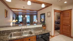 A kitchen with granite countertops, stainless steel sink, and a built-in dishwasher.