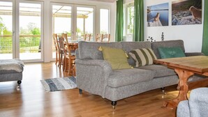 A spacious living room with a grey sofa, wooden coffee table, and a dining area with wooden chairs. - Awesome home in ånimskog with WiFi (Ånimskog)