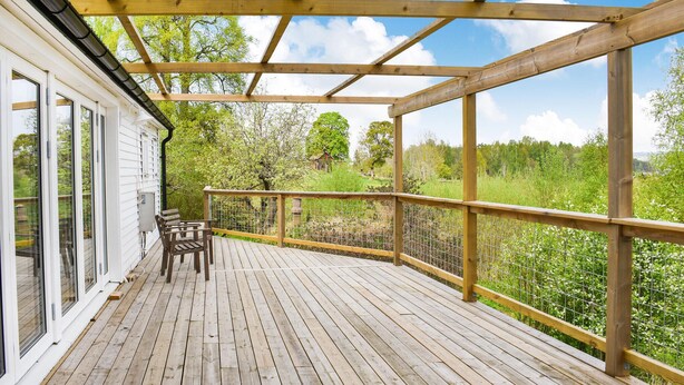 A wooden deck with a bench and a table, overlooking a lush green landscape. - Awesome home in ånimskog with WiFi (Ånimskog)
