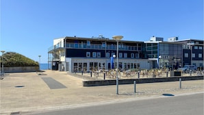 A modern hotel with a two-story structure, outdoor seating area, and a view of the ocean. - Awesome home in Falkenberg (Falkenberg)