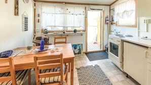 A cozy kitchen with a wooden table, chairs, and a stove. - Awesome home in Falkenberg (Falkenberg)