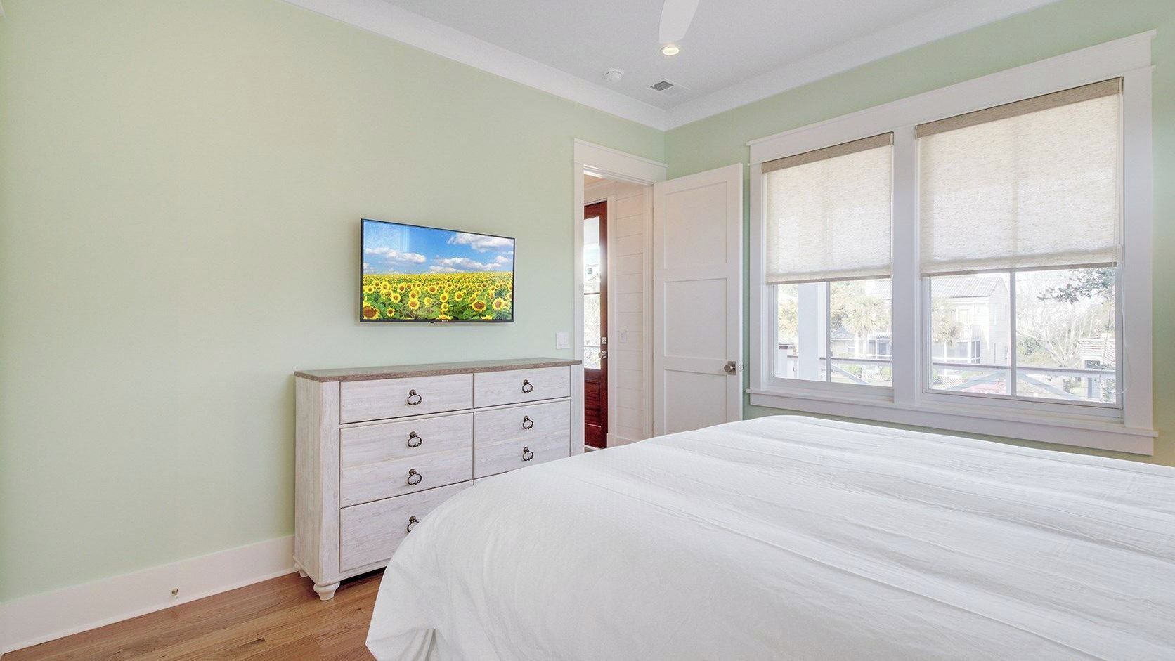 Una camera da letto con un letto, una cassettiera, un quadro e una finestra.