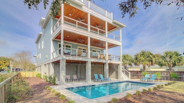 A two-story house with a swimming pool, outdoor seating, and a wooden deck. - 616 Carolina Boulevard by Avantstay Ocean Views From Decks (Isle of Palms)