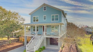 A two-story house with a covered front porch and a staircase leading to the upper level. - 616 Carolina Boulevard by Avantstay Ocean Views From Decks (Isle of Palms)