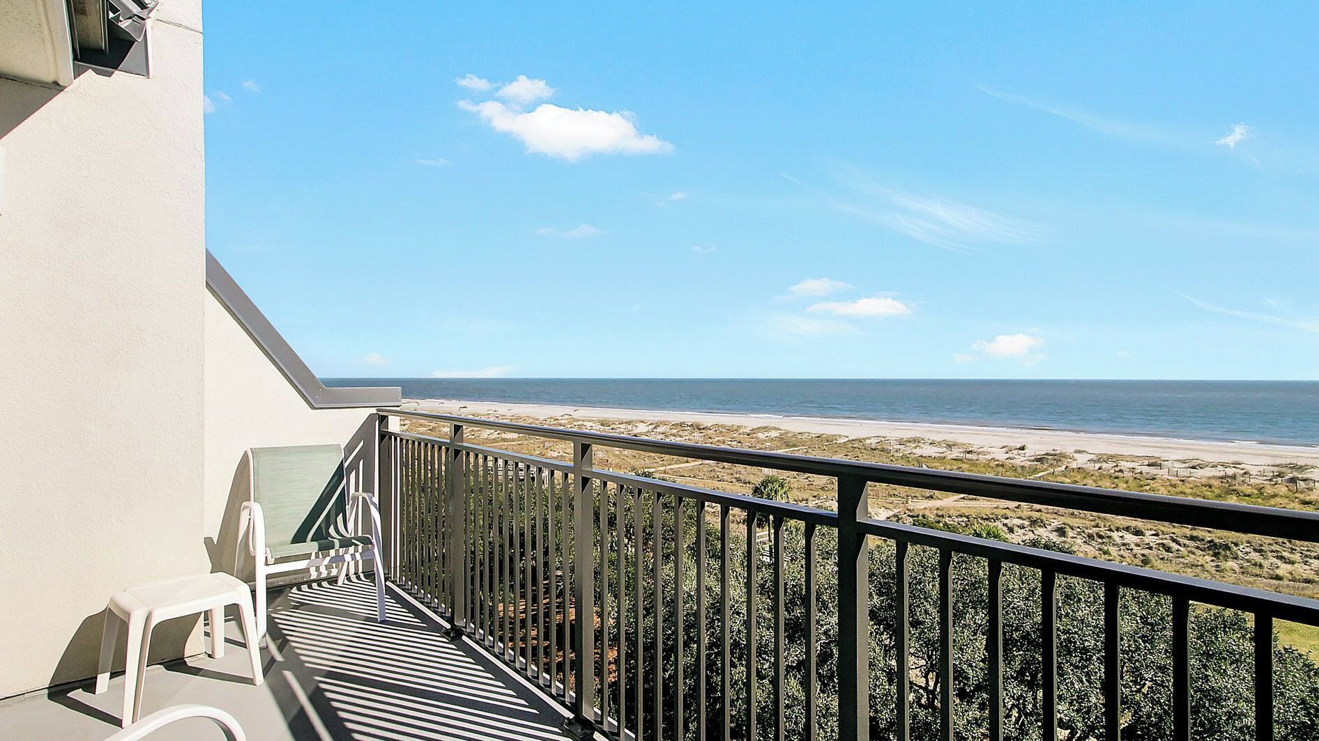 Un balcón con vista a la playa y al océano.