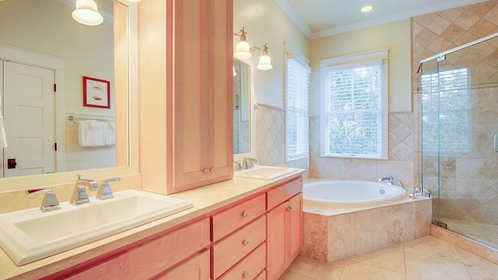 Une salle de bain avec deux lavabos, une grande baignoire, une douche à l’italienne et un grand miroir.