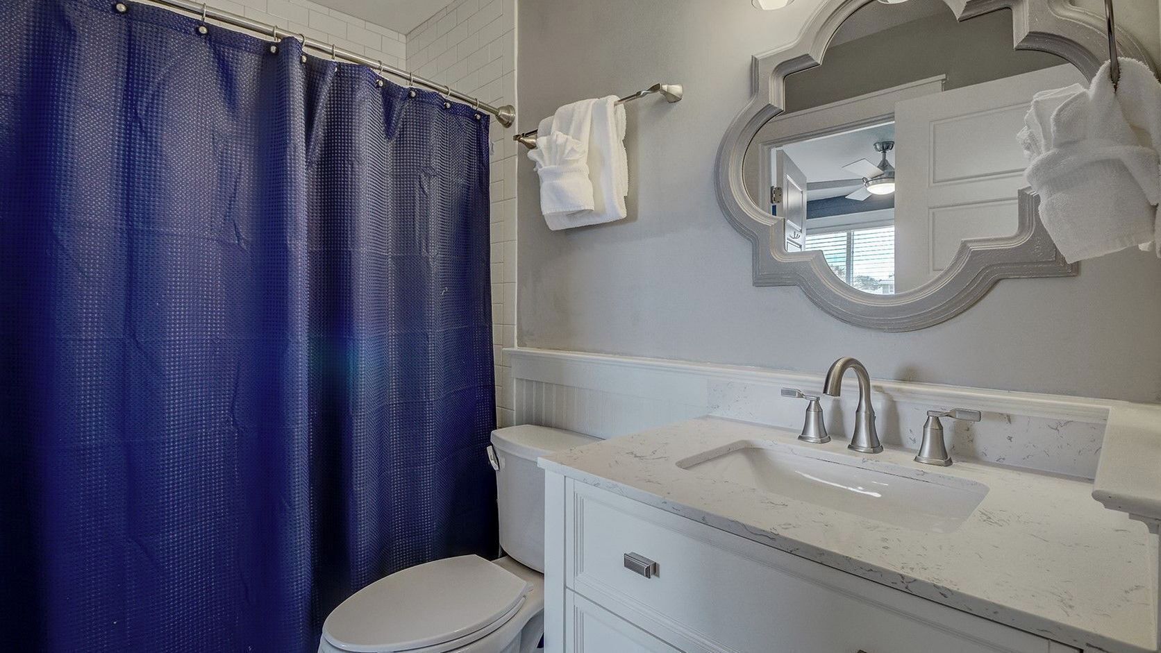 A bathroom with a toilet, sink, and shower curtain.