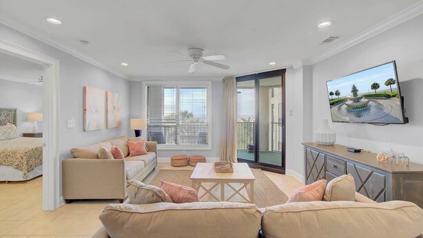 A modern living room with a sofa, a coffee table, and a TV mounted on the wall. - 207 Summerhouse by Avantstay Beachfront Community w/ Ocean Views! (Isle of Palms)