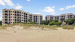A beachfront hotel with multiple floors, balconies, and a sandy beach in the foreground. - 207 Summerhouse by Avantstay Beachfront Community w/ Ocean Views! (Isle of Palms)