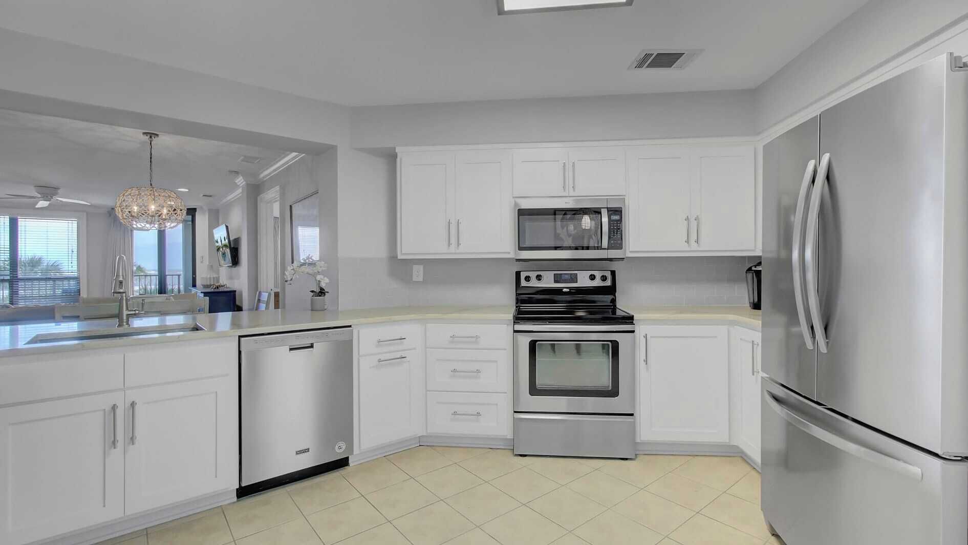 A modern kitchen with white cabinets, stainless steel appliances, and a dishwasher.