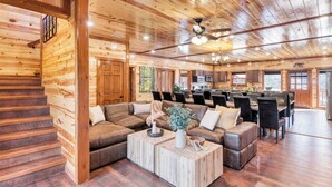 A spacious log cabin interior with a large living area, a dining area, and a kitchen. - Boon by Avantstay 40-guest Luxe Smokies Retreat (Sevierville)