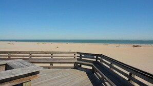 A wooden deck with a view of a sandy beach and the ocean. - 216 C Shipwatch by Avantstay Shared Pool + Ocean Views + Walk to the Beach (Isle of Palms)