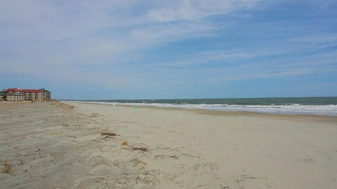 A beach with a building in the background.
