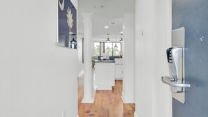 A modern kitchen with white cabinetry, a central island, and pendant lighting. - 314 C Shipwatch by Avantstay Oceanfront With Ocean View (Isle of Palms)