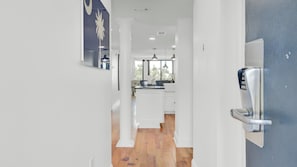 A modern kitchen with white cabinetry, a central island, and pendant lighting.
