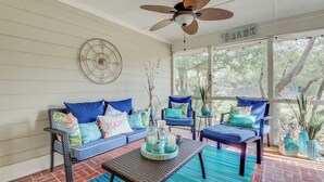 A sunroom with a ceiling fan, wicker furniture, and a view of trees. - 26 Fairway Dunes by Avantstay Wild Dunes Villa w/ Community Pool (Isle of Palms)