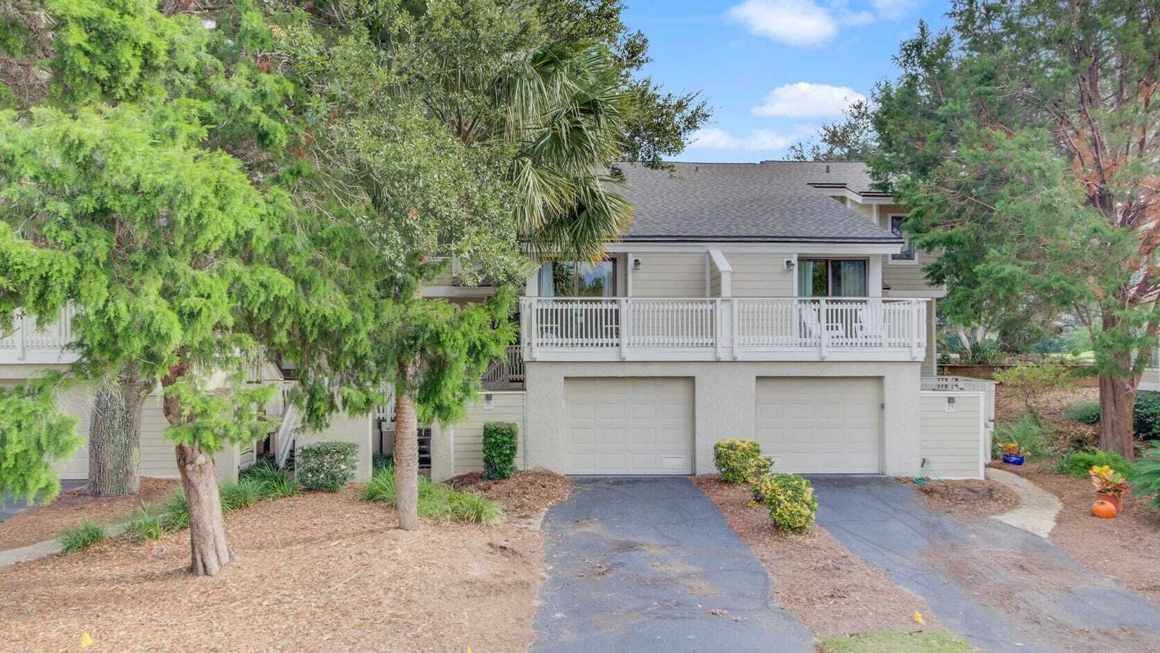 A two-story house with a front garage, a balcony, and a driveway leading to the entrance.
