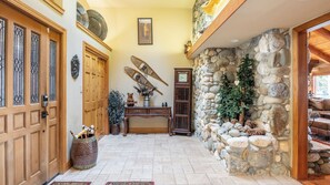 A stone wall, wooden doors, a clock, and a rustic interior. - Luxury Incline Village Cabin w/ Lake Views, Game Room, Firepit & Beach Access (Incline Village)