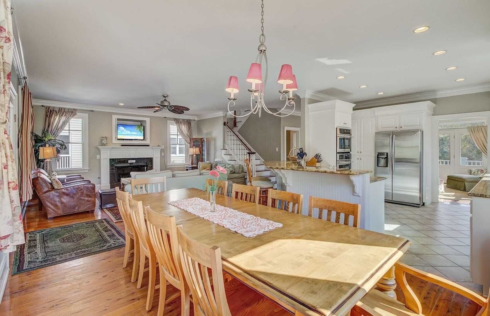 A spacious kitchen with a dining area, wooden furniture, and a chandelier.