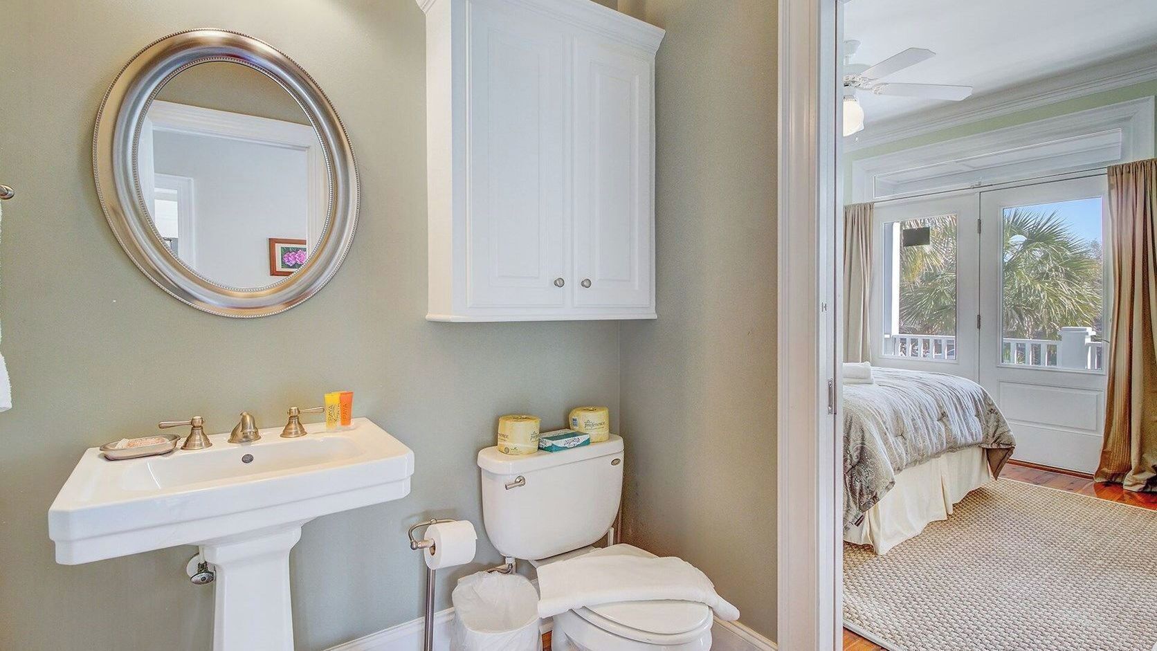 A bathroom with a sink, toilet, and mirror.