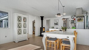 Una cocina moderna con armarios blancos, una isla central y una estufa empotrada.