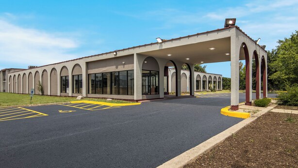 Un bâtiment doté d’une entrée abritée, de grandes fenêtres et d’un parking avec des places délimitées.