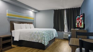 Habitació d'hotel amb un llit, una televisió, una taula i una cadira.