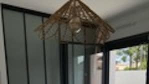 Una stanza moderna con un letto, una porta scorrevole in vetro che dà su un balcone e una ventola a soffitto.