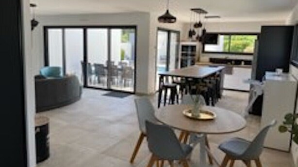 Una cucina moderna con zona pranzo, ampie finestre e vista sull'esterno.