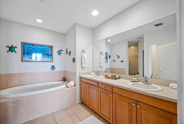 Une salle de bain moderne avec une baignoire, deux lavabos, des meubles en bois et un grand miroir.
