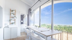 A modern kitchen with a large window, white cabinetry, and a wooden ladder shelf with plants. - Lovely home in El Rafol D'Almunia (El Rafol D'Almunia)