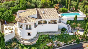 A large white villa with a tiled roof, a swimming pool, and lush greenery. - Lovely home in El Rafol D'Almunia (El Rafol D'Almunia)