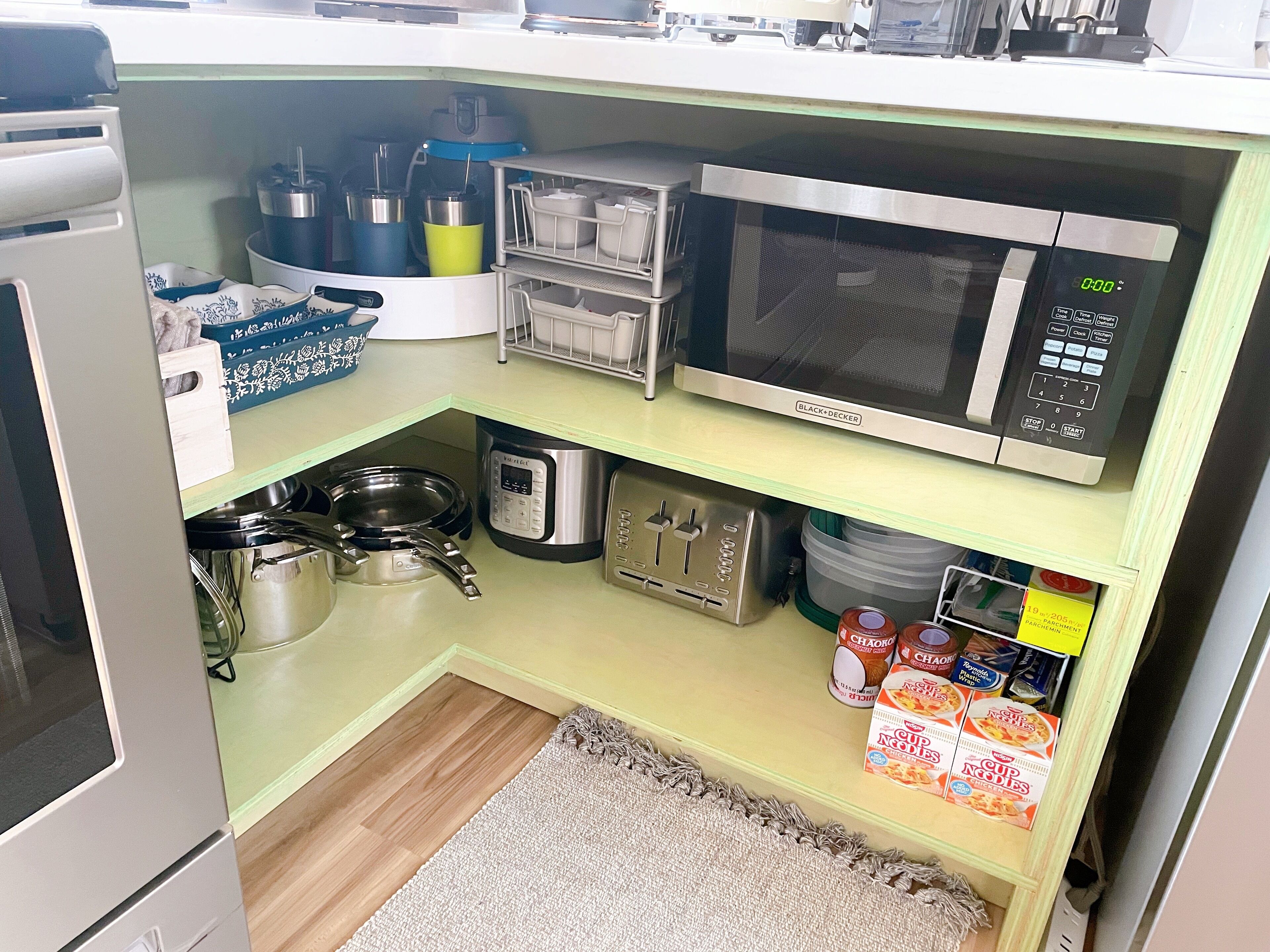 Une cuisine compacte équipée d’un four à micro-ondes, d’une bouilloire, d’un grille-pain et de boîtes de conservation.