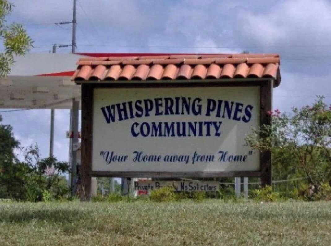 Une enseigne pour la communauté de Whispering Pines, avec le slogan : « Votre deuxième maison ».