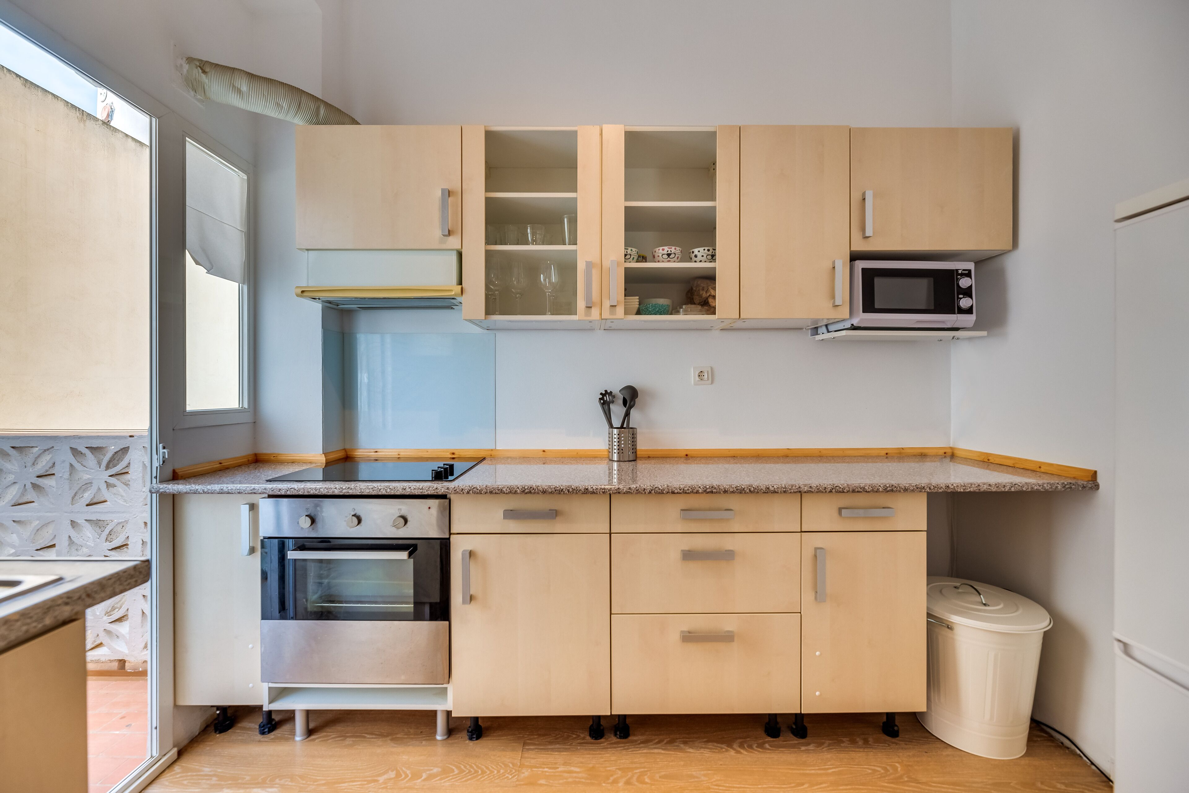 Une cuisine compacte dotée d’un four, d’un micro-ondes et de placards intégrés.