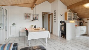 Eine moderne Küche mit Einbauherd, weißen Schränken und einem Essbereich mit Tisch und Stühlen.
