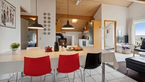 Eine moderne Küche mit einer zentralen Kochinsel, roten Stühlen und einem Kamin.