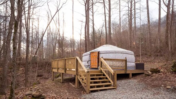 A yurt with a wooden deck and a staircase leading to the entrance. - Three-Bedroom Bungalow.... (Robbinsville)