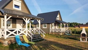 Una hilera de casas de madera con barandillas blancas y un patio cubierto de césped.