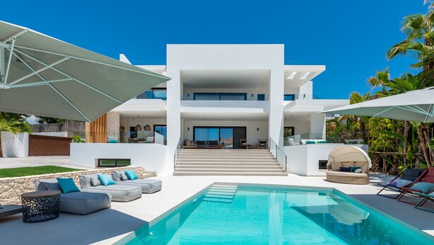 A modern two-story house with a swimming pool, outdoor seating, and a staircase leading to the entrance. - All About Playas Andaluzas Villa (Marbella)