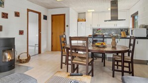 Un salon chaleureux avec une cheminée, une table à manger en bois et des chaises.