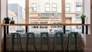Eine Bar mit vier grünen Barhocker und einer Holztresen.