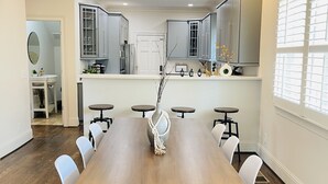 Una cocina moderna con armarios grises, encimera blanca y un ventilador de techo.