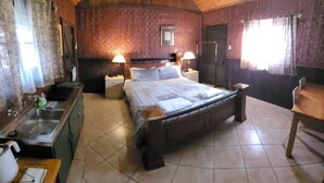 A wooden-paneled bedroom with a bed, bedside tables, a sink, and a window with curtains. - "Talbot" Rustic style accommodation with Mod Cons (Katrine)