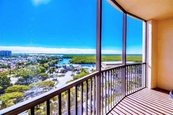 A balcony with a view of a coastal area, including a beach and a marina.