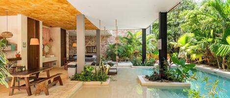 A pool area with a wooden bench, a table, and potted plants.