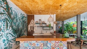 A kitchen with a wooden ceiling, hanging pendant lights, a tiled backsplash, and a wooden counter. - Manor Tulum by The Spot Rentals (Tulum)