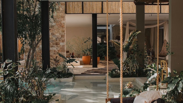 A spacious indoor area with a hanging swing, a small pool, and various plants. - Manor Tulum by The Spot Rentals (Tulum)