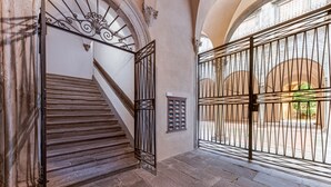 Un escalier en pierre avec des rampes métalliques menant à un niveau supérieur.